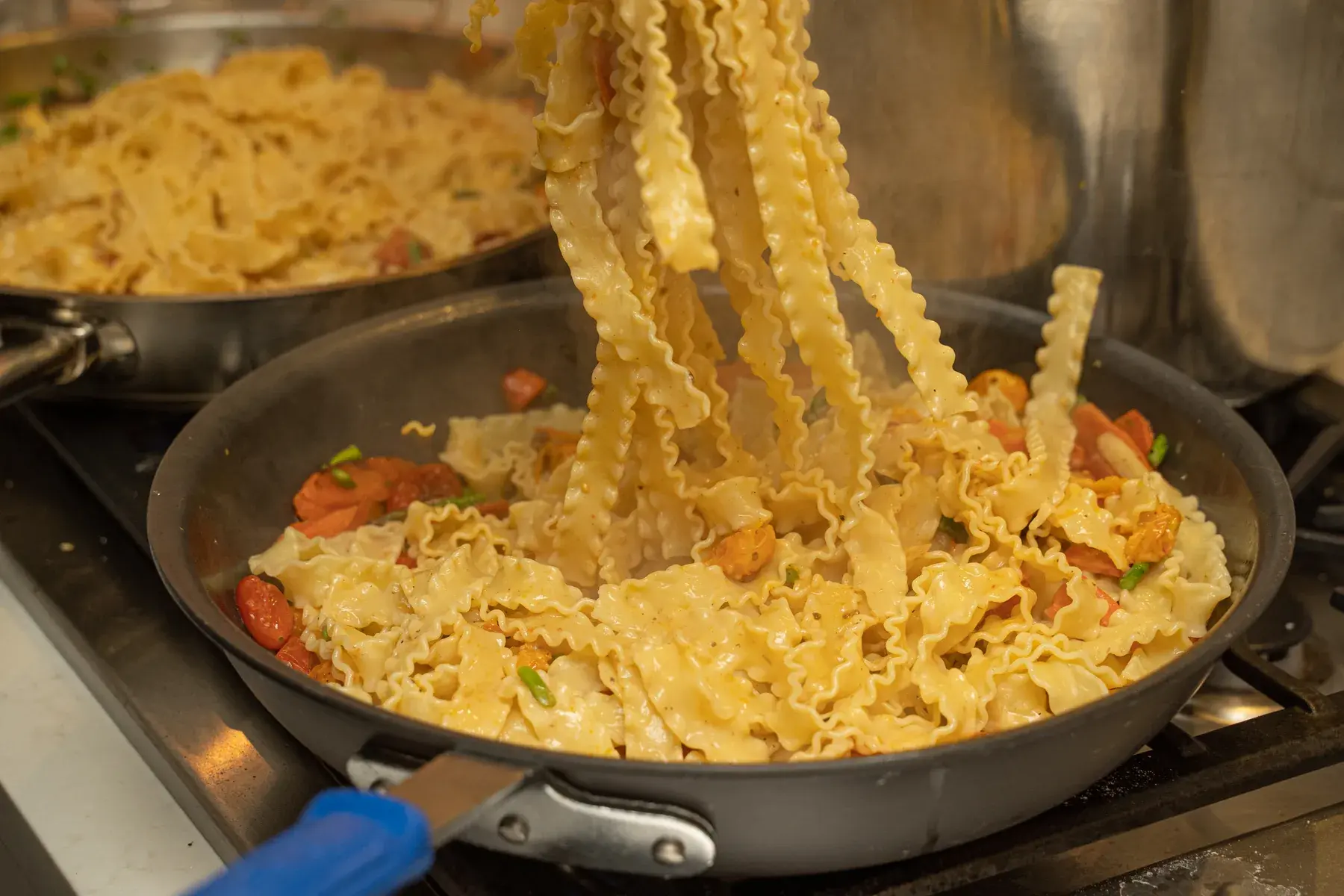 Fresh pasta being prepared in saute pans by Dragonfly Catering for an upcoming event