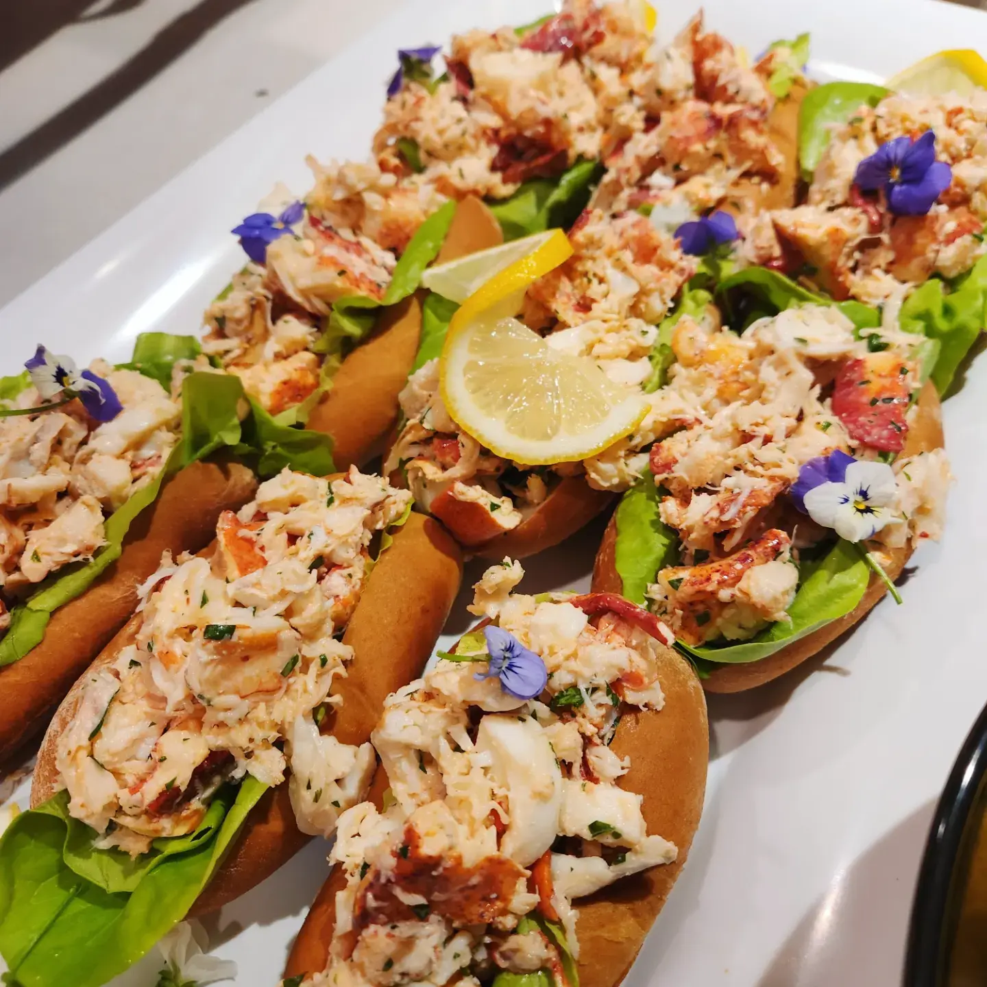 Lobster rolls finished with edible flowers by Dragonfly Catering